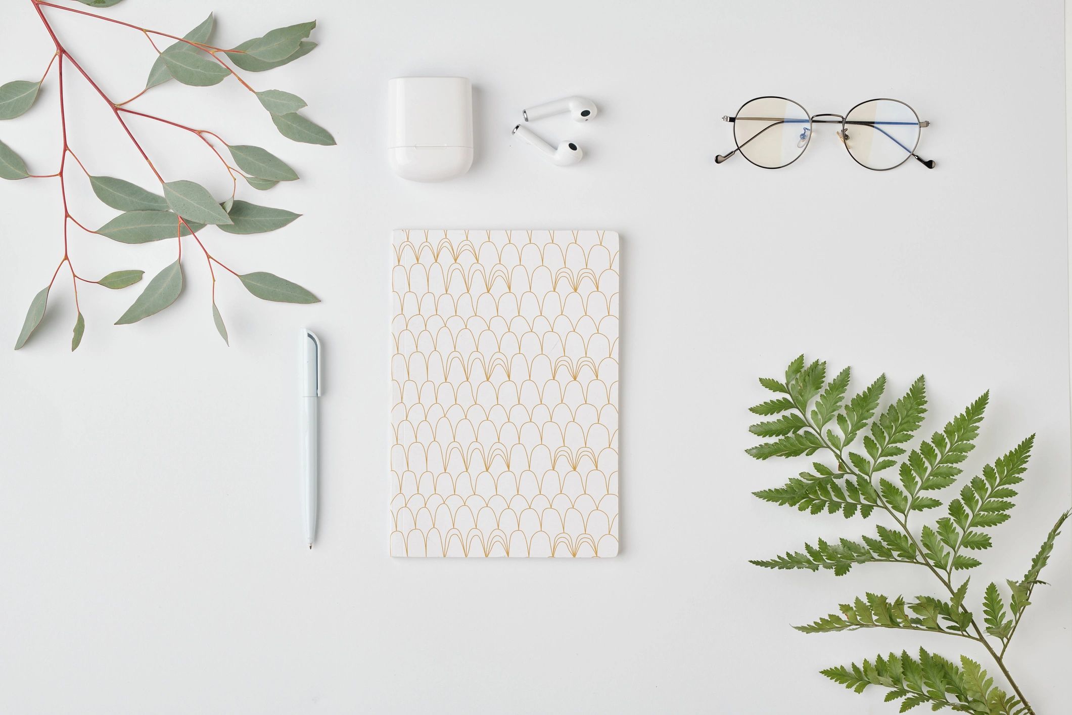 Minimal wellness flat lay with notebook and greenery