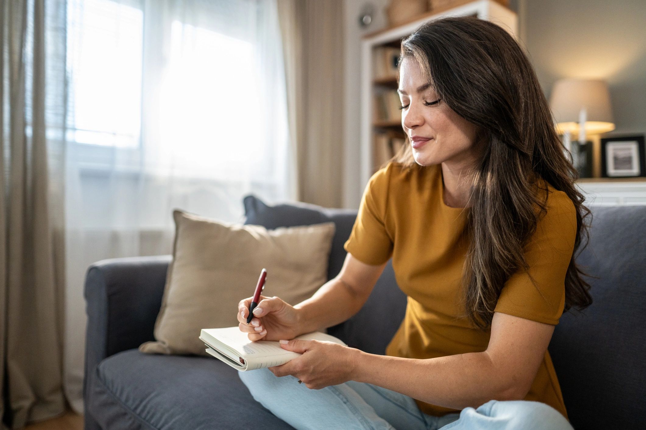 Woman journaling at home in soft natural light