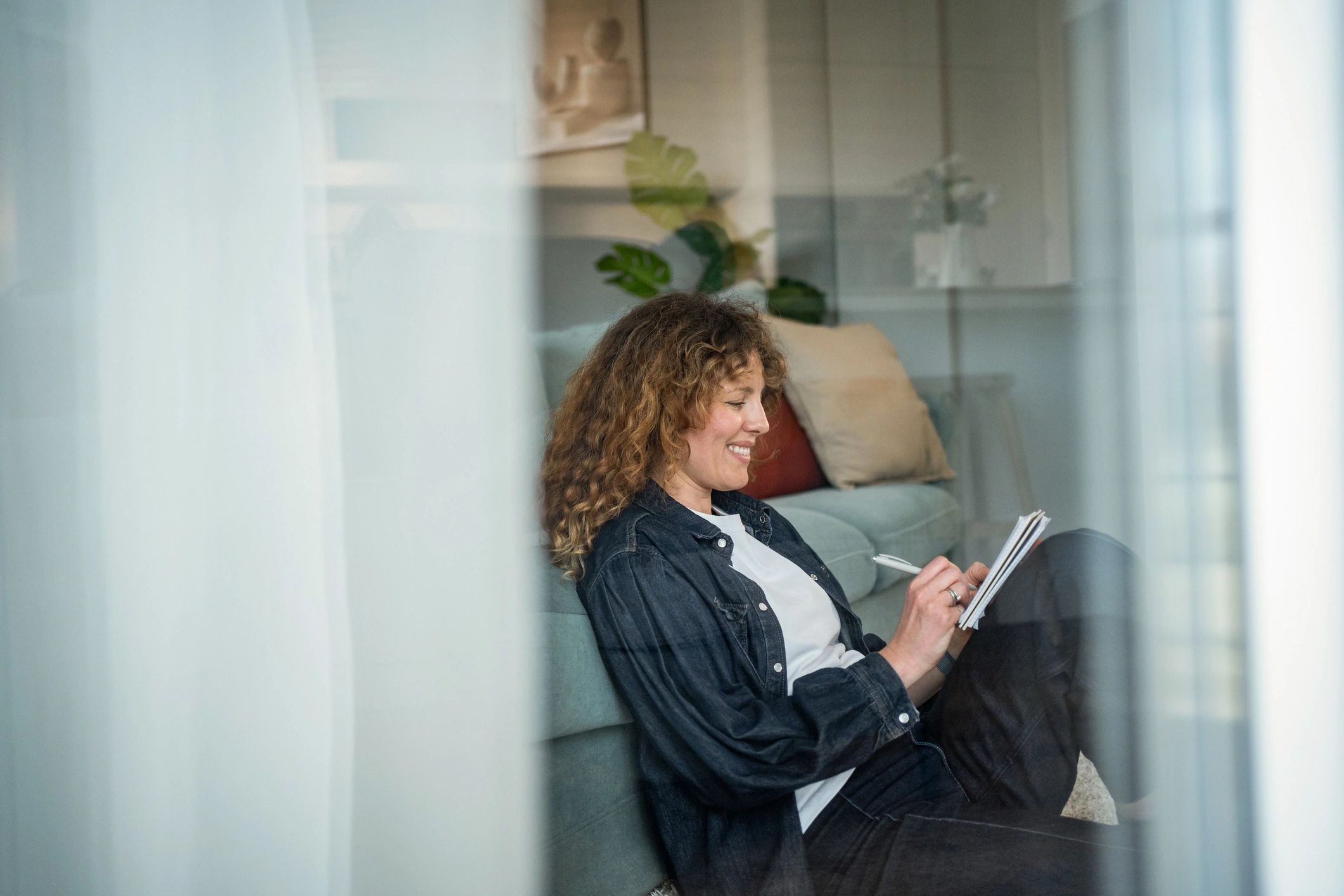Woman writing in a notebook during a mindful moment at home